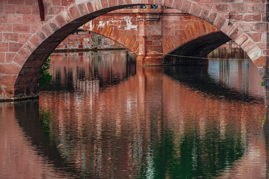 Un puente de ladrillo reflejado en el agua.